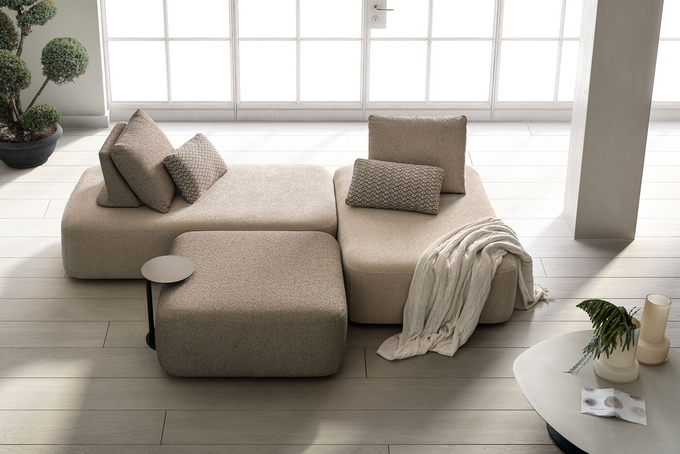 Divano componibile in tessuto beige con forme arrotondate