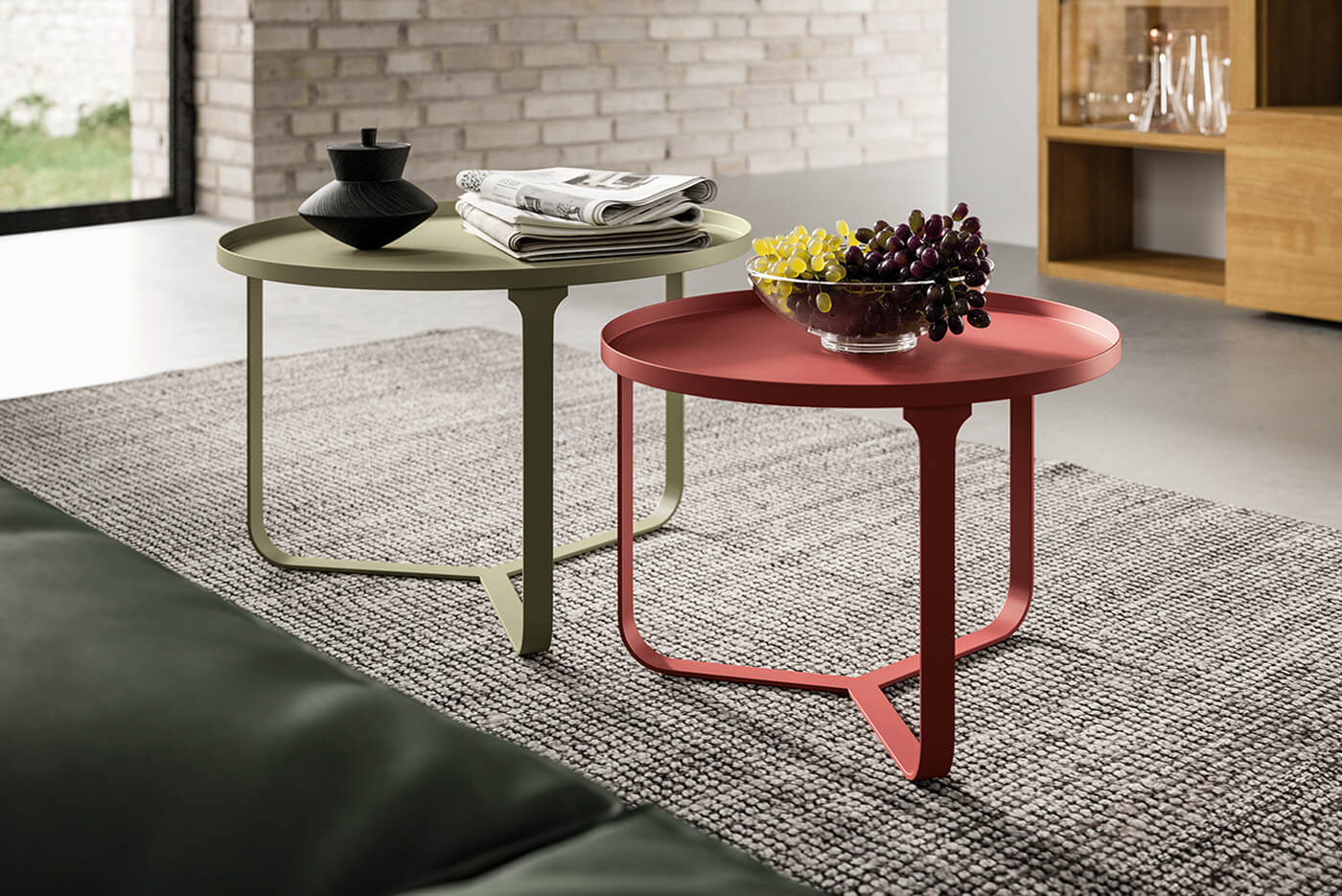 Tavolini rotondi in metallo colorati con bordo rialzato, disponibili in rosso e verde salvia