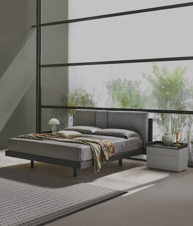 Letto matrimoniale rialzato con testiera imbottita in tessuto grigio chiaro e base nera moderna